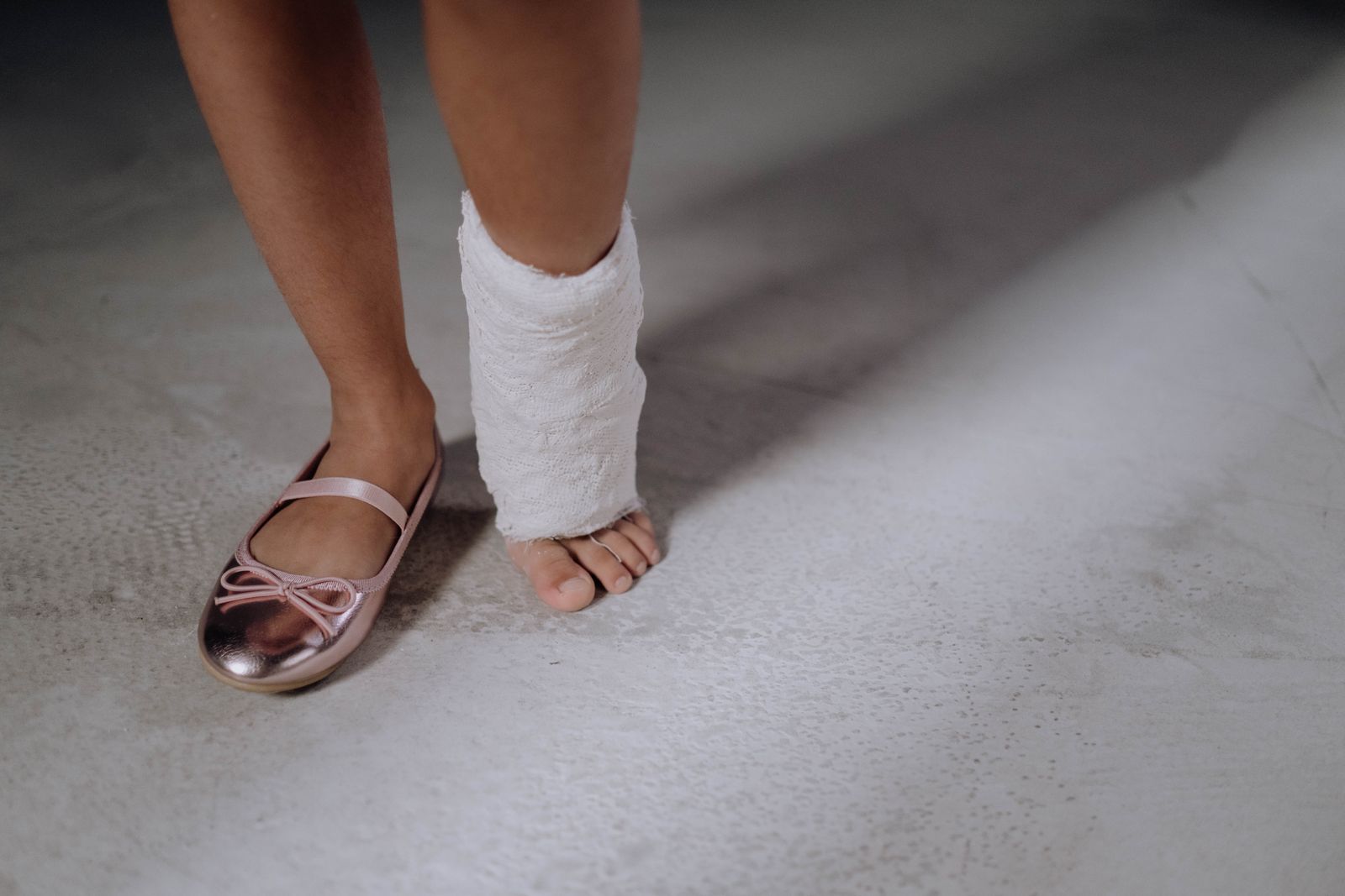 Close-up van het been van een kind in het gips met een roze schoentje